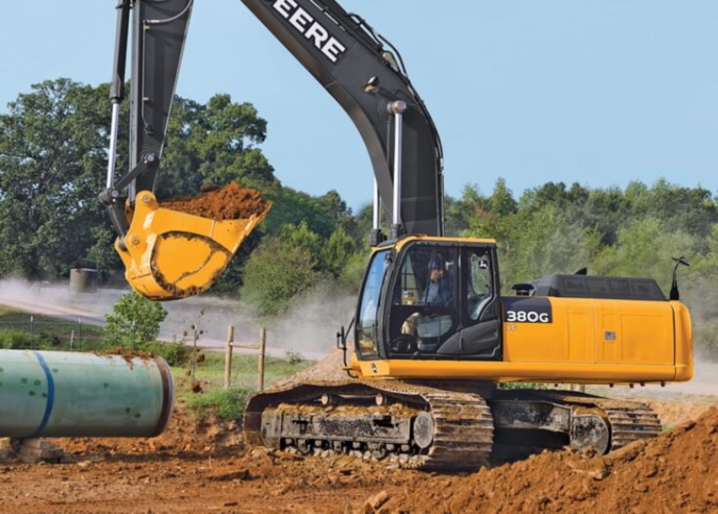 Excavator placing pipe on site